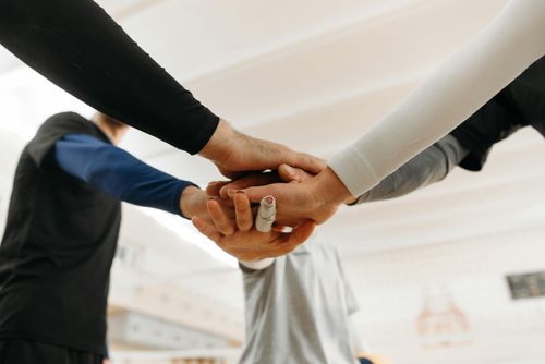 Eine Gruppe im Kreise, die ihre Händer übereinander legt